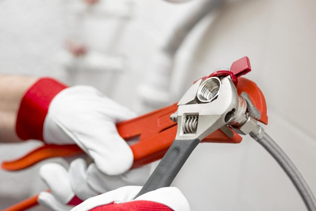 Plumber holding pipe wrenches for an emergency repair in Highland