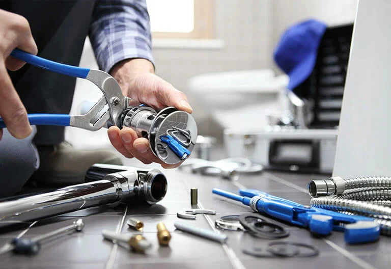 Technician repairing a plumbing fixture with professional tools in Highland