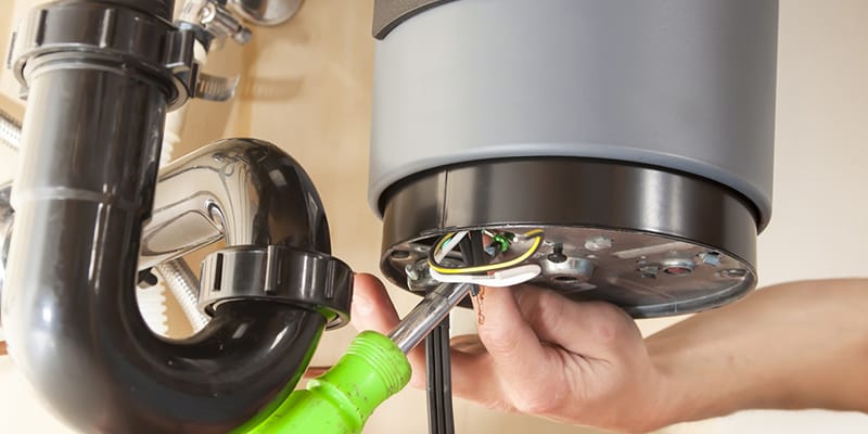 Technician repairing the heating element of a water heater in Highland