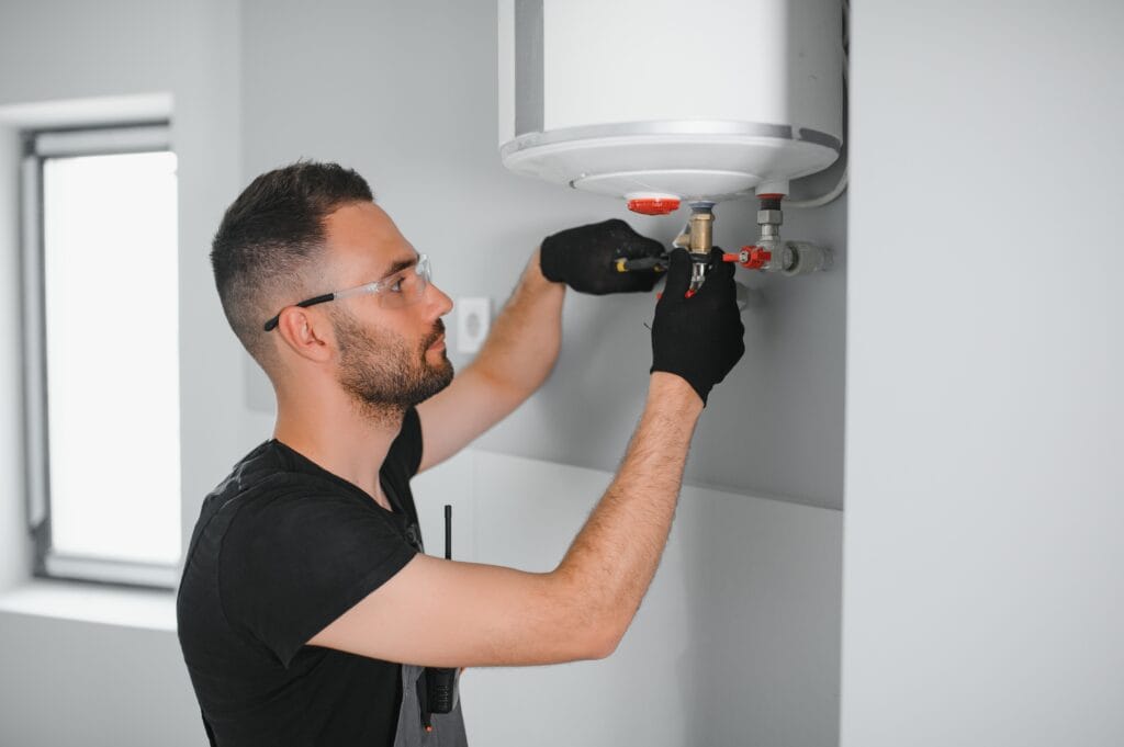 Technician performing water heater maintenance in Highland
