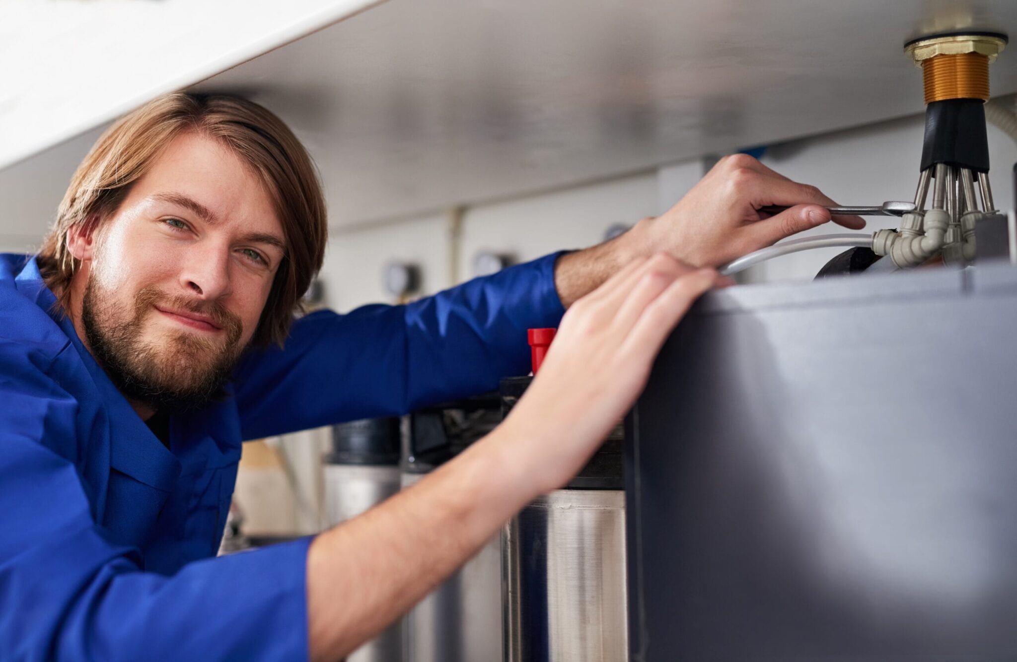 Technician servicing a residential water heater tank in Highland