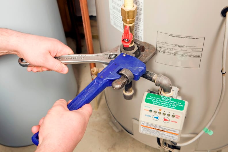 Plumber repairing a water heater valve in Highland
